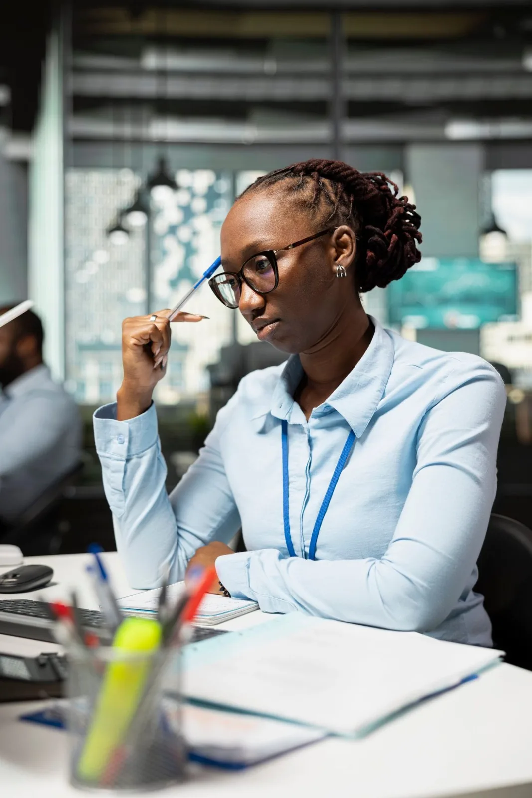 A young professional in glasses working at an office desk